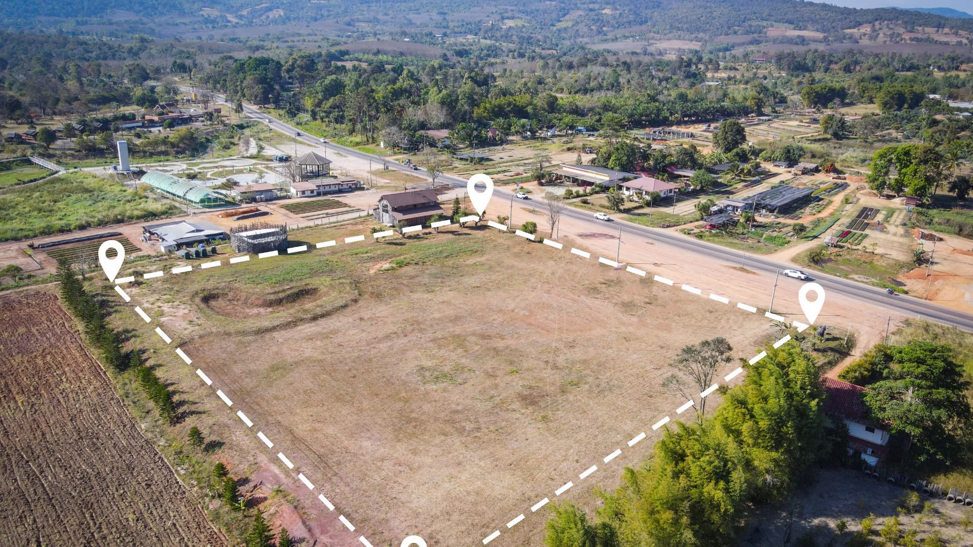 Aerial view of empty lot with location markers in rural community